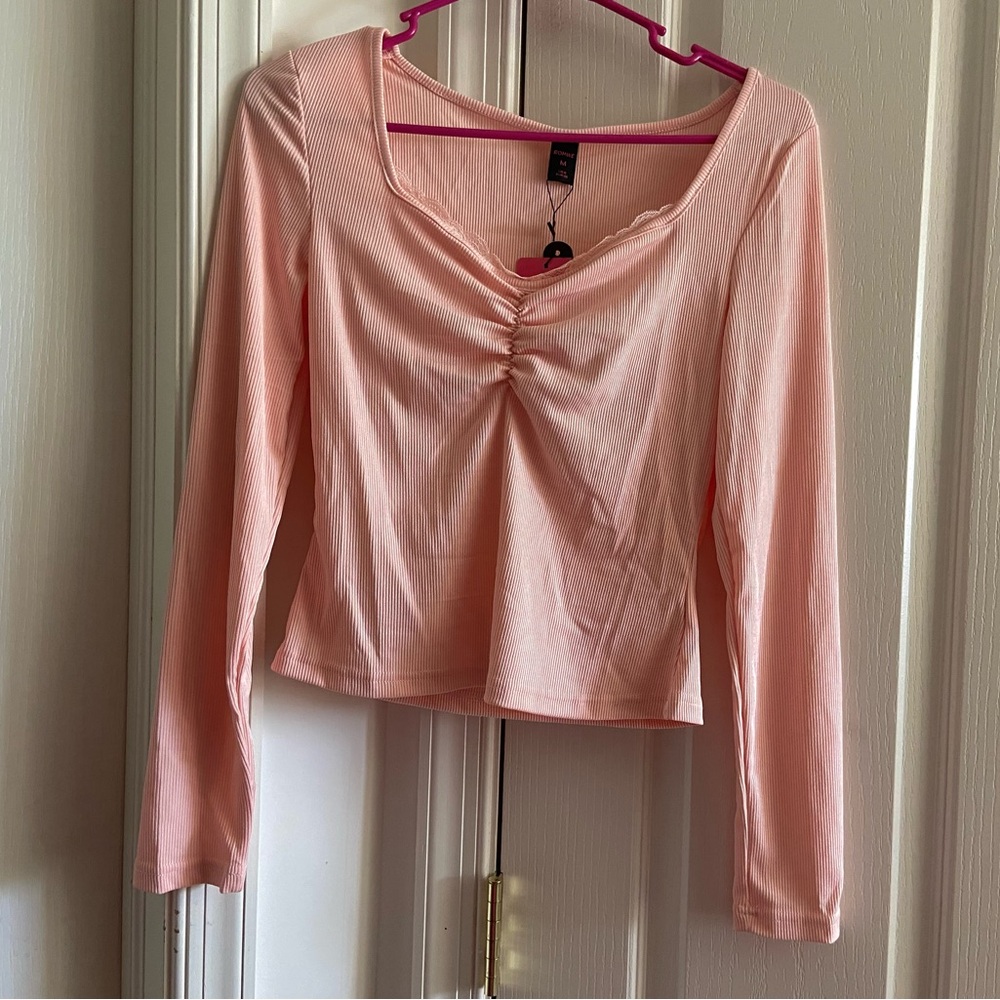 Pink long sleeved slightly cropped shirt